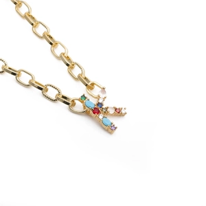 Detailed macro view of gold-plated K letter pendant with micro-pave colored zircon stones