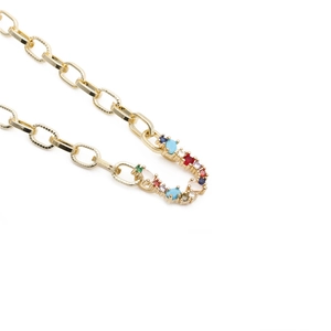 Detailed close-up of a golden chain necklace with a colorful zircon micro-pave letter pendant