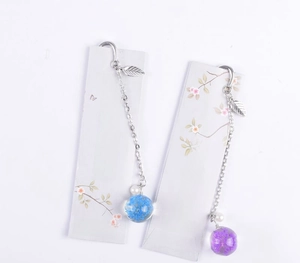 Detailed silver metal leaf bookmark with dried flower pendant charms on display card