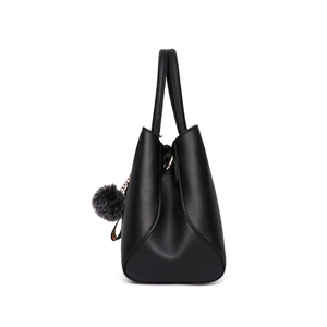 Fashionable black faux leather handbag with floral embroidery and grey faux fur pompom charm