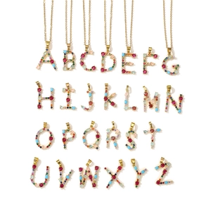 Macro shot of 26 alphabet pendants with colorful cubic zirconia in gold settings
