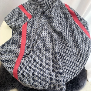 Detail of soft cotton scarf with blue Greek fret pattern and red striped borders