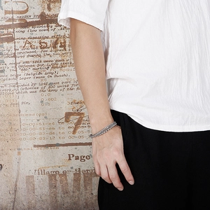 Close-up of double-layered silver titanium steel Cuban chain bracelet on a male wrist
