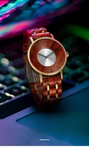Macro view of wooden and gold alloy watch links against a neon bokeh laptop background