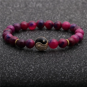 Detailed close-up of 8mm pink and purple agate beads with a golden crystal yin yang charm