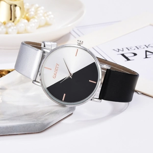 Close-up of GAIETY watch with two-tone black and white dial on marble coaster