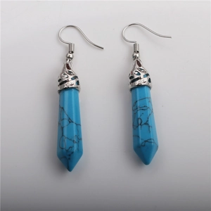 Detail of blue turquoise hexagonal prism drop earrings with silver ornate hook caps
