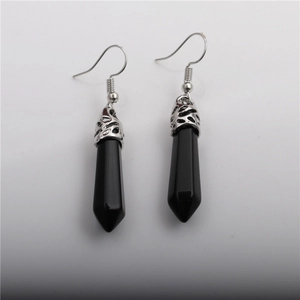 Detail of silver drop earrings with hexagonal black crystal stones on grey background
