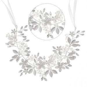 Detail view of bridal headband with silver leaves, faux pearls, and white ribbons