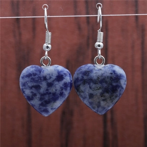Close-up of heart-shaped blue and white turquoise earrings with silver metal hooks