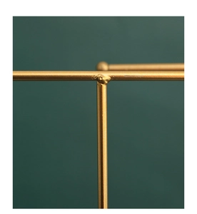 Detailed T-junction of the golden metal earring stand with a dark green background