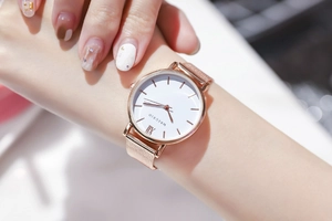 Gros plan d'une montre rose gold à bracelet milanais avec cadran à chiffres romains