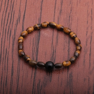 Men's natural tiger eye stone bead bracelet with irregular oval stones on wood background