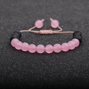 Handmade beaded bracelet with pink frosted stones and black lava beads on an adjustable cord