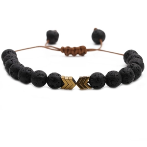 Adjustable woven lava stone bracelet with bronze arrow beads on a plain white background