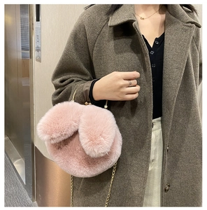 Close-up of pink plush rabbit ear bag featuring soft faux fur and elegant gold metal chain