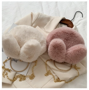 Detailed view of plush rabbit ear bag featuring golden chain and metal handle accent