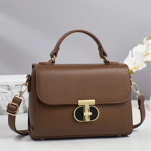Elegant brown pebbled leather handbag with T-shaped metal lock and adjustable strap