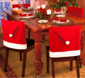 Festive red Santa hat chair covers with white plush pompoms for Christmas dining decor