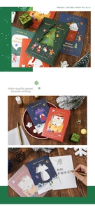 Detailed view of hollow 3D Christmas card with angel and tree designs on a wooden table