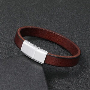 Detail of brown leather bracelet featuring a polished silver magnetic metal clasp