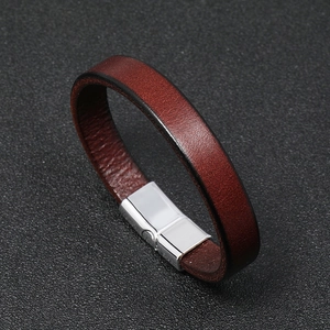 Detail view of red-brown leather bracelet featuring a sleek silver magnetic metal clasp