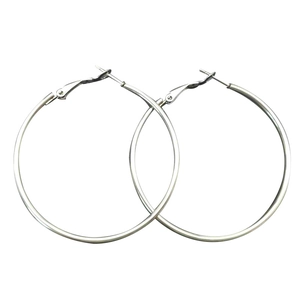 Minimalist silver stainless steel hoop earrings in a diagonal professional photography layout
