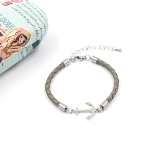 Detail of grey braided leather bracelet with silver anchor charm and extension chain
