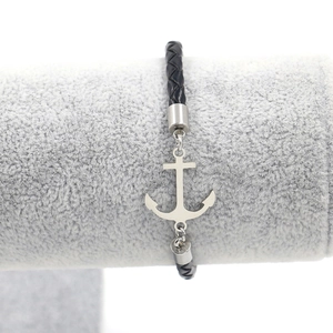 Detail of silver anchor pendant on black woven leather cord bracelet for men and women
