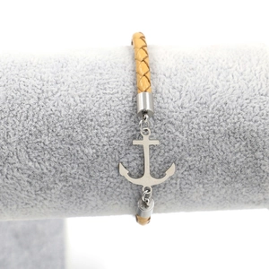 Detail of a brown braided leather anchor bracelet displayed on a grey velvet jewelry stand
