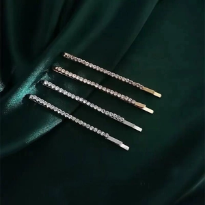 Macro detail of rhinestone hairpins in gold and silver finish on silk fabric
