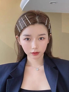 Close-up of model wearing sparkling silver rhinestone hair clips and clover necklace