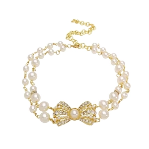 Collana girocollo a due strati di perle con fiocco dorato e cristalli scintillanti