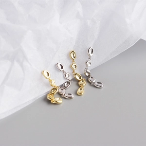 Detail showing gold and silver S925 sterling silver tassel earrings on art paper background