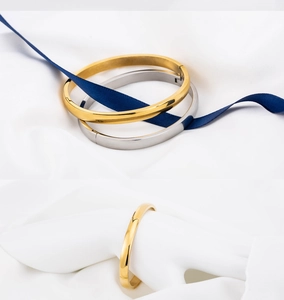 Close-up of polished 18K gold and silver plated 6mm stainless steel bangle bracelets