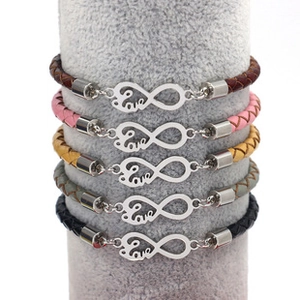 Macro detail van veelkleurige gevlochten leren armbanden met oneindige liefde bedels