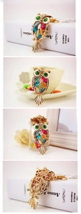 Detailed close-up showing multicolored crystals and intricate hollow carving on owl keychain