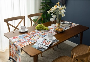 Detail of chenille table runner with fish pattern and navy blue pompom tassel fringe