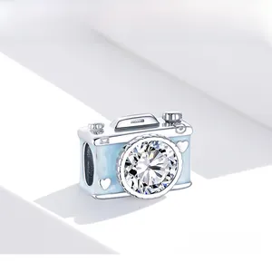 Macro detail of a S925 sterling silver camera charm with blue enamel and zircon stone