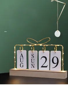 Close-up of wooden LED calendar with golden metal frame and warm white lighting detail