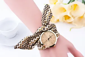 Detail of Geneva watch with gold dial and yellow-black striped fabric ribbon strap