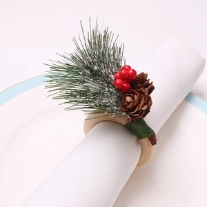 Christmas napkin ring with snowy pine needles, red berries and pinecones on a wooden ring