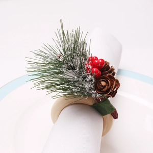 Cedar napkin ring with pine needles, red berries and cones on a white ceramic plate