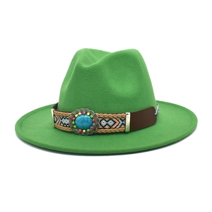 Dettaglio di un cappello fedora verde con pietra turchese e fascia etnica intrecciata