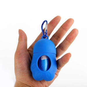 Portable blue paw-shaped pet waste bag dispenser with metal carabiner in hand