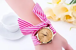 Close-up of Geneva floral fabric strap watch tied in a bow with gold case and white dial