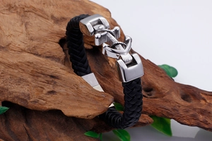 Close-up of black braided leather men's bracelet with silver stainless steel anchor clasp