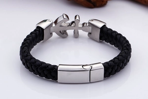 Detailed view of black woven leather strap and silver stainless steel anchor clasp closure