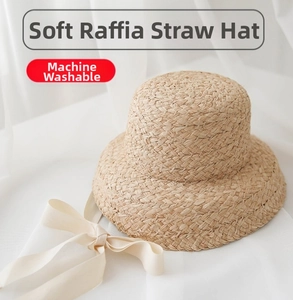 Close-up of soft raffia straw weave texture with cream ribbon on a sun hat