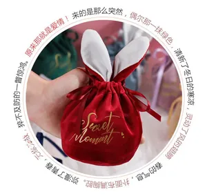 Detail of red velvet favor bag with rabbit ears and golden Sweet Moment lettering